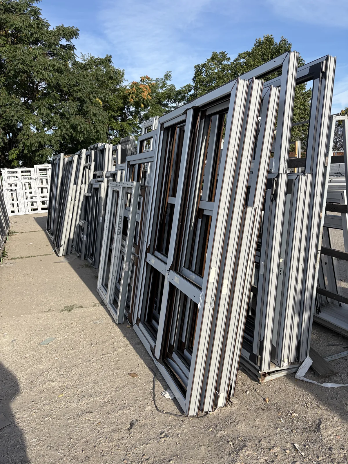 Marcos y hojas de ventanas de distintos tamaños colocados en soportes al aire libre